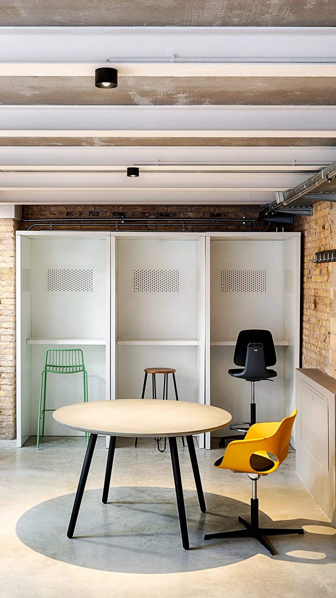 Luminaires Arkoslight Puck au plafond d’un espace de coworking