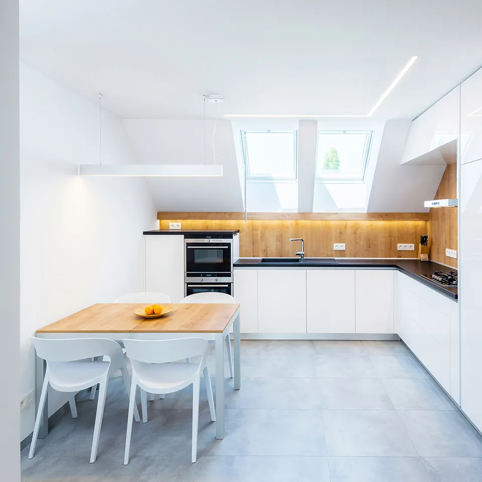 Profil linéaire Indelague Reba 50 au plafond d’une cuisine ouverte avec table