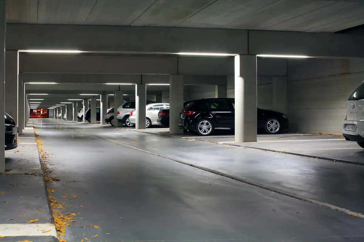 Luminaires Indelague TTP 50 posés au plafond d’un parking couvert, au-dessus des places de stationnement