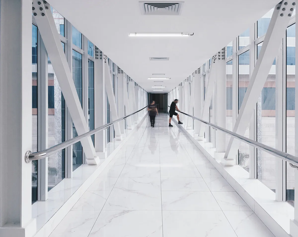 Luminaires tubulaires Indelague TTP 50 au plafond d’une passerelle vitrée