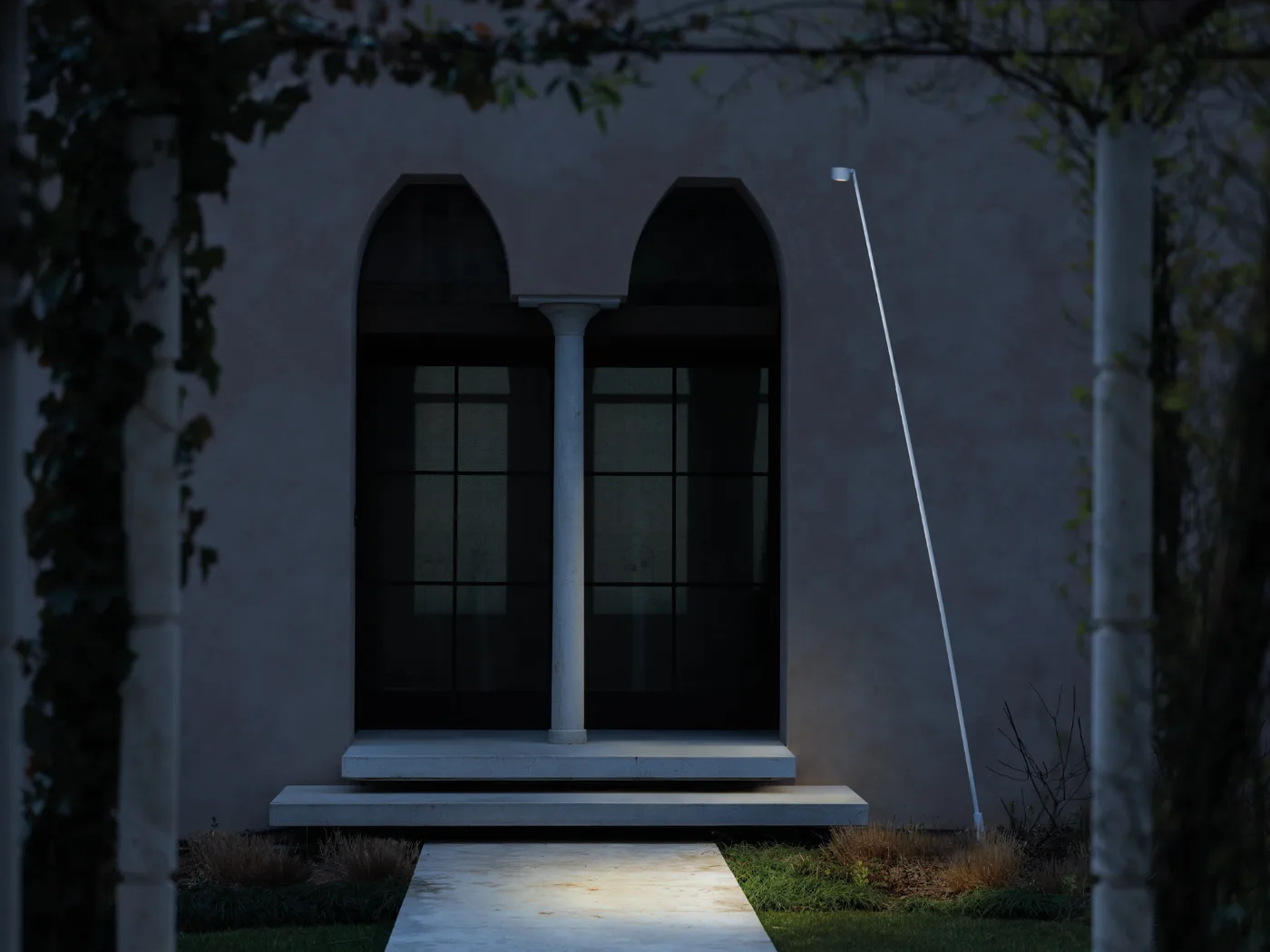 Lampadaire Lombardo Hasta éclairant de nuit l’allée d’entrée d’une demeure