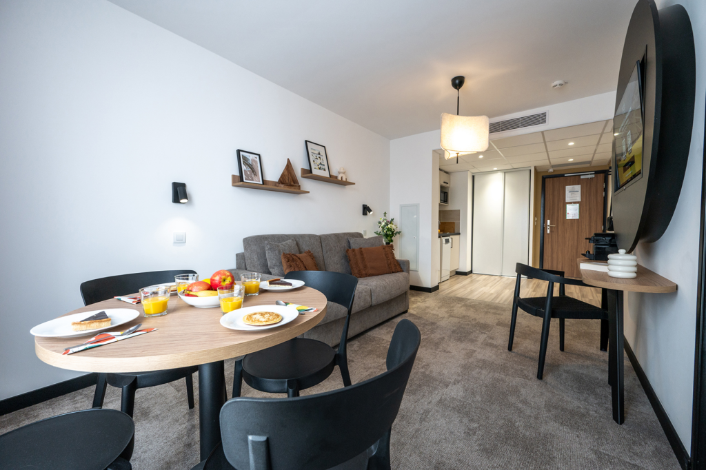 Séjour d'un appartement de la résidence Nemea Appart'Hotel Sunset Nice Arenas, suspension en tissu et appliques orientables