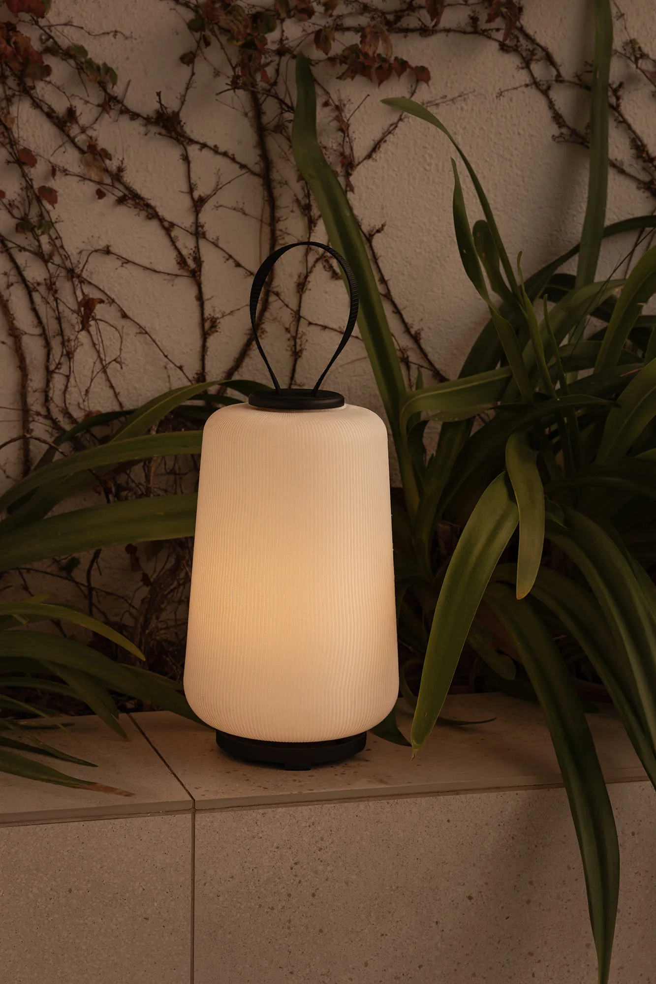 Lampe portable d'extérieur Faro Muna posée sur une terrasse