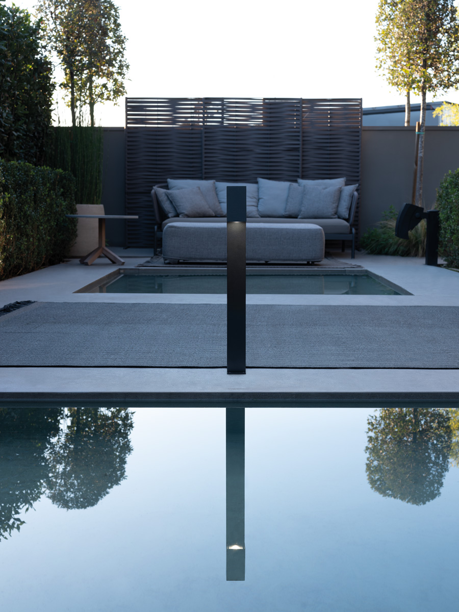 Borne Lombardo Trend 60 Post au bord d'un bassin, devant une terrasse