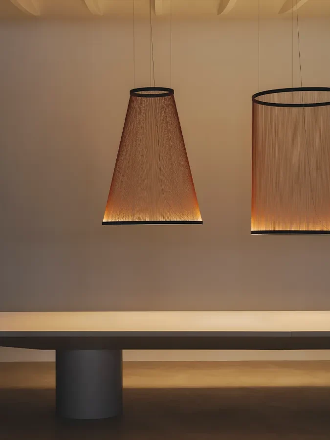 Deux suspensions Vibia Array au-dessus d'une longue table